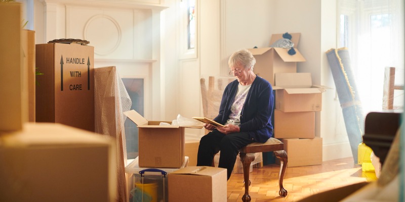 Retired lady sitting with her packed stuff